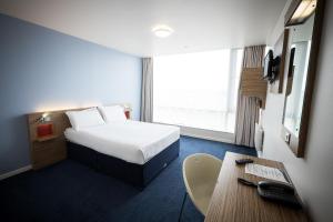 a hotel room with a bed and a desk at Travelodge Limerick Castletroy in Limerick