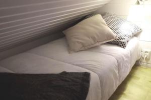a white bed with two pillows on top of it at Aikku cabin in the heart of Lapland, free Lapin Kota, Budget week in Ylläs +6 photos