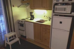 a small kitchen with a white refrigerator and a sink at Aikku cabin in the heart of Lapland, free Lapin Kota, Budget week in Ylläs