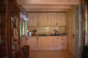 a kitchen with wooden cabinets and a sink at Domek myśliwski w górach in Ujsoły