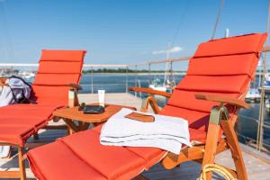 two red chairs and a table on the deck of a boat at Lewisia in Barth