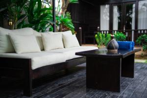 ein Sofa und einen Couchtisch auf einer Terrasse in der Unterkunft Villa Lumbung Sari - Tropical Balinese Experience in Canggu