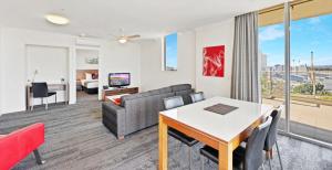 a living room with a couch and a table at Hotel Diana South Brisbane in Brisbane