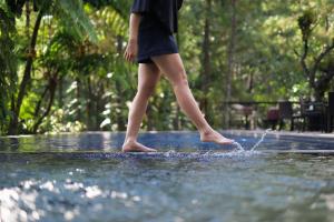 a woman is standing in a water fountain at House Sangkuriang in Bandung
