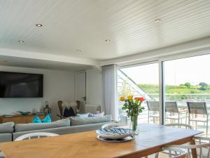una sala de estar con una mesa y un sofá en The Penthouse, en Salcombe