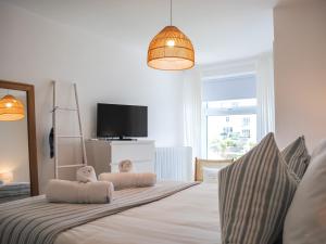 Un dormitorio con una cama con dos almohadas y un televisor. en The Penthouse, en Salcombe