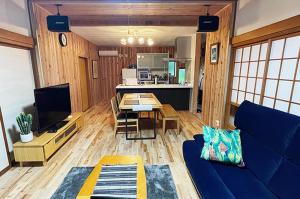 Una sala de estar con un sofá azul y una mesa. en Five Tree House -九十九里 香取, 海も山も大満喫できるコテージ-, en Katori
