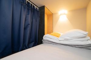 a bedroom with a bed and a blue curtain at Tokyo Guest House Ouji Music Lounge in Tokyo