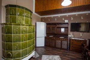 a kitchen with a green wall with a refrigerator at Nola vendeghaz in Magyarhertelend