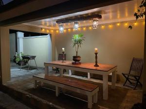 a living room with a table and a bench and lights at OAK HOUSE, Entire holiday home, Self catering, fully equipped, double storey, 3 bedroom, 2 bathroom, outside entertainment, Braai area, 300sqm home in Hillcrest