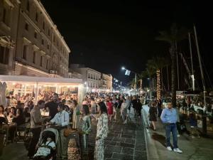 a crowd of people walking down a street at night at Centro Storico MARE FUORI in Brindisi