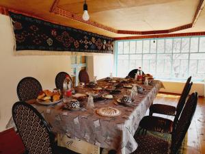 a long table with food on it in a room at MusoBarakaNur Guest House in Yukary-Ukhum