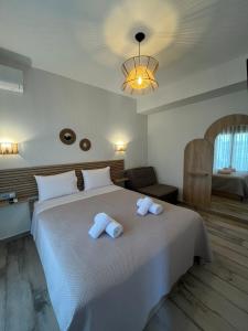 a bedroom with a large white bed with towels on it at Magdalena Seaside Apartments in Nea Roda +70 photos