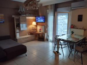 a living room with a table and a dining room at Ester's Sea Side apartment in Neoi Epivates