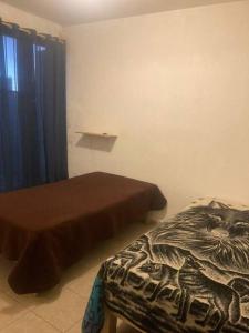 a bedroom with two beds and a blanket with a face on it at Casa de alojamiento Villa de Pozos San Luis Potosí mínimo 6 noches de reserva in San Luis Potosí
