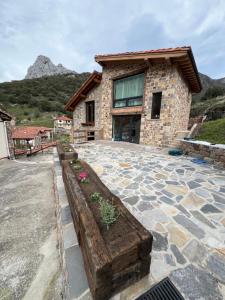 a house with a stone patio in front of it at El Gallinero de Tiago in Lebena