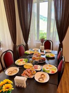 a table with plates of food on top of it at Горный дом ЛЕС и ГОРЫ Dinarsky in Karakol +43 photos