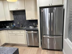 a kitchen with a stainless steel refrigerator and white cabinets at A Luxury Master Bedroom in a Condo in Los Angeles +10 photos
