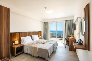 a hotel room with a bed and a view of the ocean at Apolis Beachscape Hotel in Amoopi