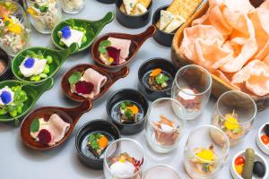 a table with many dishes of food and bread at Cross Hotel Sapporo in Sapporo