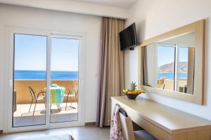 a room with a desk and a view of the ocean at Apolis Beachscape Hotel in Amoopi