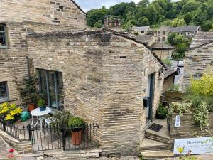 an old brick house with a balcony in a city at The Therapy Rooms Holmfirth Holiday Let in Holmfirth