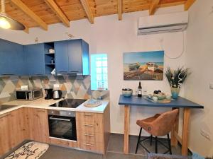 a kitchen with blue cabinets and a blue counter top at A GEORGE Luxury house in Artemida