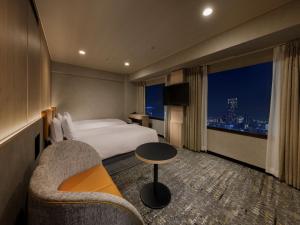 a hotel room with a bed and a couch and a window at Shinjuku Prince Hotel in Tokyo