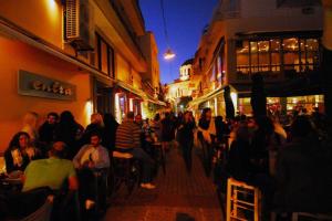 a crowd of people walking down a street at night at Casa Anna Maria in Volos in Volos +14 photos