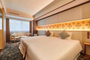 ein Hotelzimmer mit einem großen Bett und einem Schreibtisch in der Unterkunft Cross Hotel Sapporo in Sapporo + 155 Fotos
