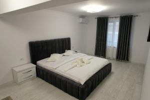 Un dormitorio con una cama grande con cabecero negro. en Apartament Cosmi Ari, en Băile Herculane