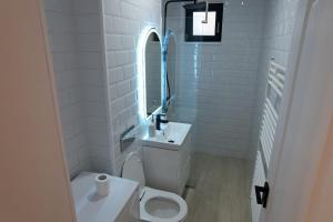 Un baño blanco con inodoro y lavabo. en Apartament Cosmi Ari, en Băile Herculane 10 fotos más