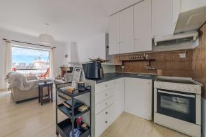 a kitchen with white cabinets and a stove top oven at Seaside escape apartment in Saronida