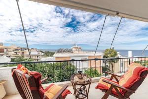 a balcony with two chairs and a table at Seaside escape apartment in Saronida