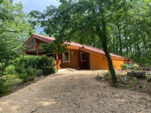 une petite maison jaune avec un arbre devant elle dans l'établissement LES REFUGES DU LOT Le Cosy, à Mauroux