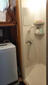 een douche in een badkamer met een deur open bij Umeya Annex in Fujikawaguchiko