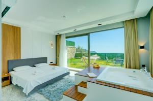 a bedroom with a bed and a tub and a window at Villa Pluto 1 - PLANET LUXURY VILLAS in İslâmlar +29 photos