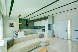 a living room with a white couch and a kitchen at Villa Pluto 1 - PLANET LUXURY VILLAS in İslâmlar