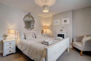 une chambre avec un lit avec un miroir et une chaise dans l'établissement April Cottage by Winterton Cottages, à Winterton-on-Sea