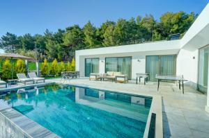 a house with a swimming pool and a patio at Villa Pluto 1 - PLANET LUXURY VILLAS in İslâmlar