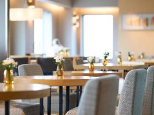 a row of tables and chairs with flowers in jars at Cerulean Tower Tokyu Hotel, A Pan Pacific Partner Hotel in Tokyo