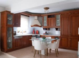 a kitchen with wooden cabinets and a table and chairs at Domus Meus in Mastambás