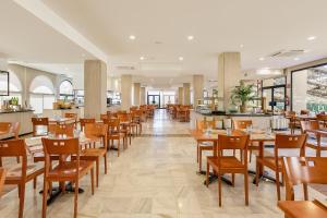 a dining room with wooden tables and chairs at Sol Sancti Petri Aparthotel in Chiclana de la Frontera