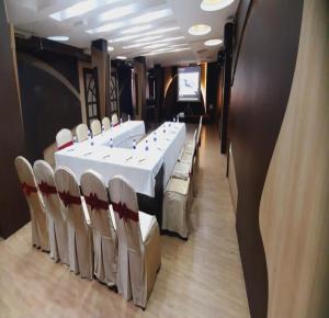 a conference room with a white table and chairs at NavaRATNA Delight in Coimbatore