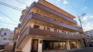 um edifício alto com uma varanda numa rua em CoCo SPACE em Kagoshima