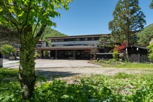 an office building with a tree in the foreground at Hirayukan in Takayama +83 photos