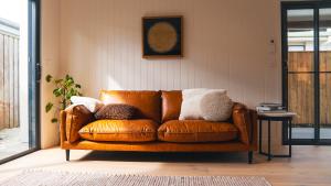 a brown leather couch sitting in a living room at Blue Ash Studio in Lennox Head