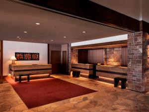 a lobby with two benches and a table at Hakuba Tokyu Hotel in Hakuba