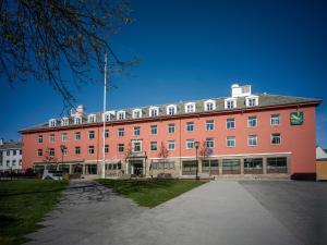a large red building with a flag on top of it at Quality Hotel Grand Kristiansund in Kristiansund