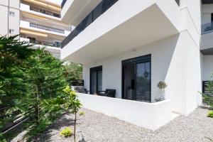 a white house with black doors and a courtyard at Aegean Escape Luxury Apartment in Rhodes Town +5 photos